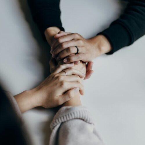 person in black long sleeve shirt holding babys feet